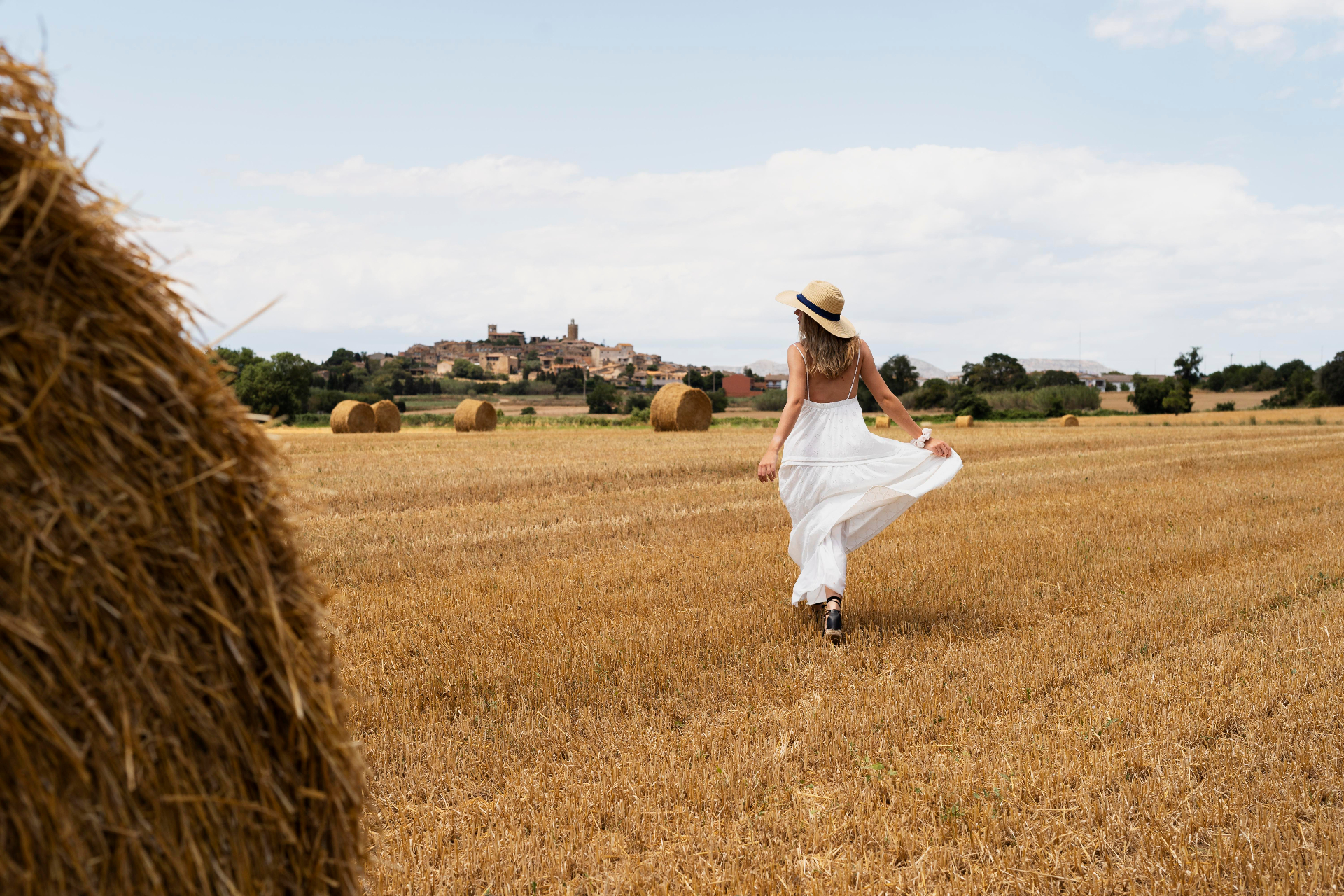 Figura de vestido branco a caminhar num campo de trigo alentejano